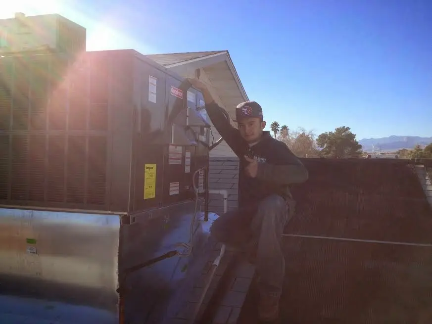 HVAC technician performing AC Tune-Up on a rooftop unit in Four Corners